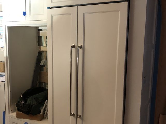 Paneled cabinet doors around a refrigerator