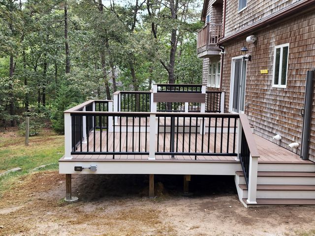Deck with railings beside a shingled house