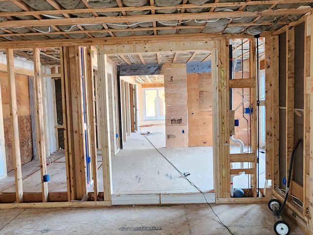 Framed walls and ceiling joists down a hallway