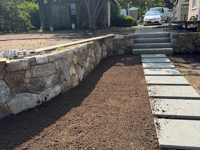 Stone retaining wall with stone steps and bluestone stepping stones