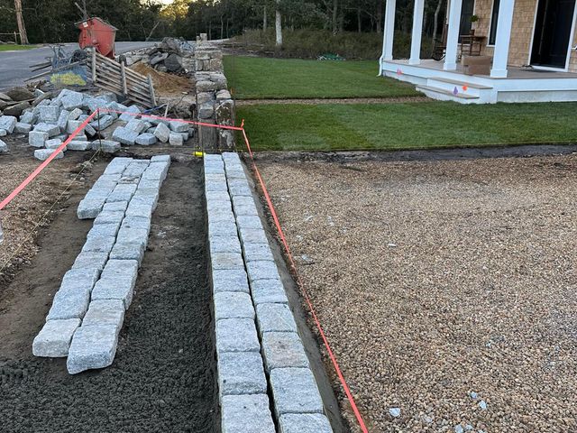 Granite cobblestone borders being set for a walkway